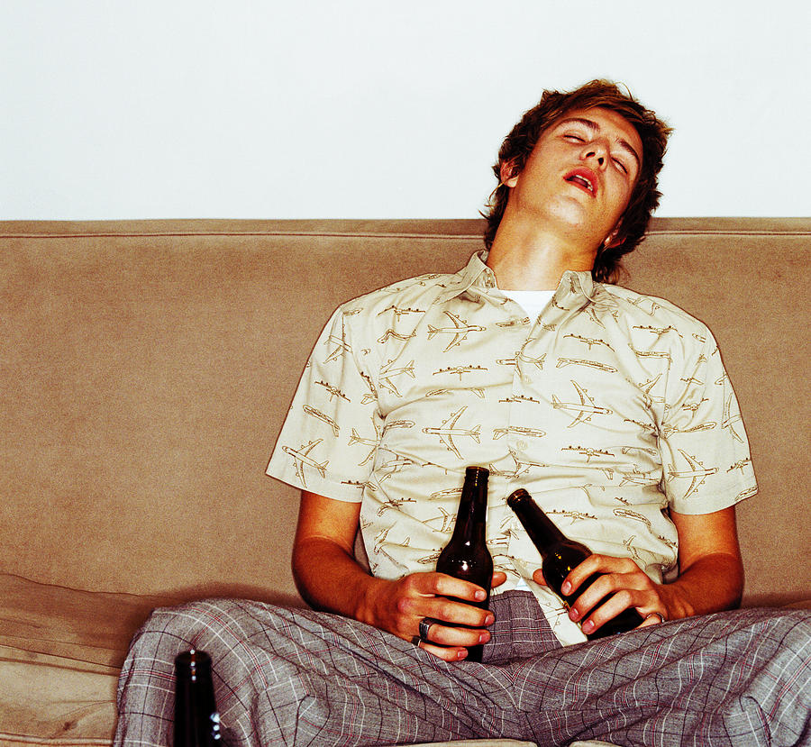 Portrait Of A Young Man Asleep On The Couch After Drinking Too Much Beer Photograph by George Doyle