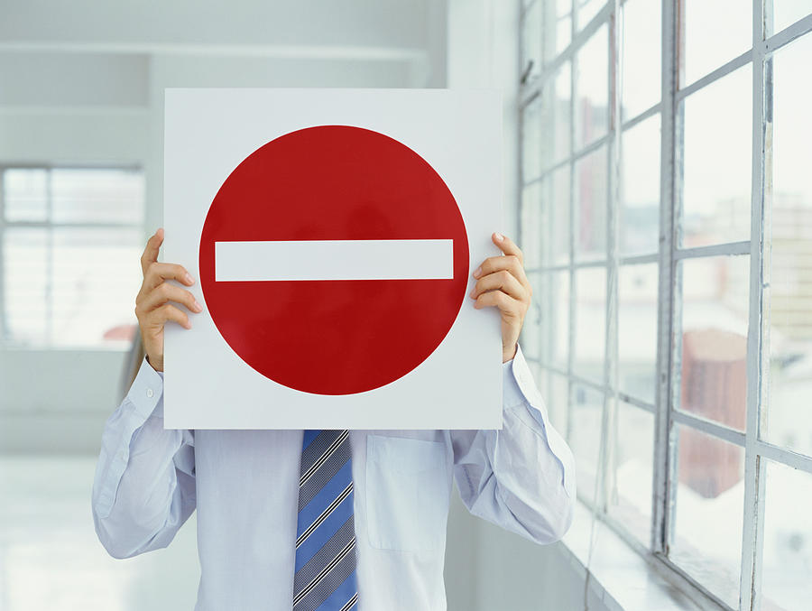 Portrait of a young man holding a no entry sign Photograph by Stockbyte