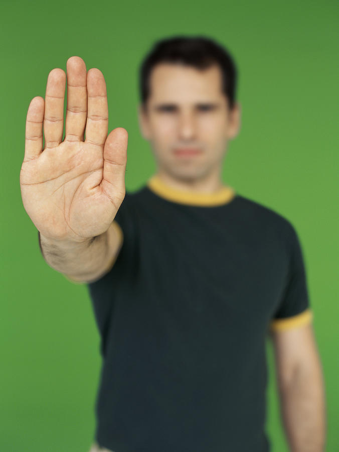 Portrait Of A Young Man Showing A Stop Gesture Photograph by Stockbyte