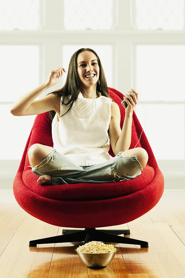 Portrait of a young woman sitting on chair smiling Photograph by Colin Anderson Productions pty ltd