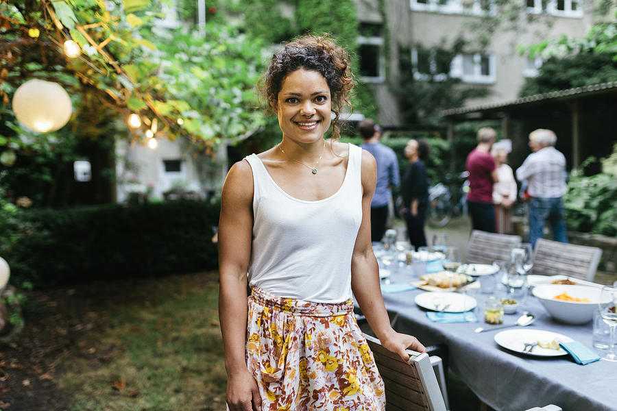 Portrait Of A Young Woman Smiling At Family BBQ Photograph by Hinterhaus Productions