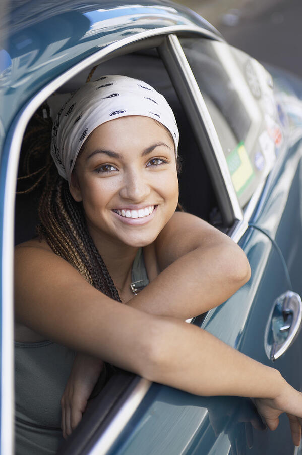 Portrait of a Young Woman Wearing a Bandana Sitting in a Car Photograph by Digital Vision.