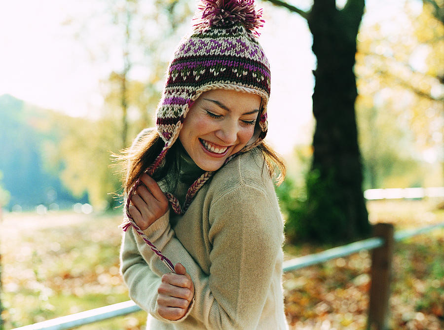 Portrait of a Young Woman Wearing a Bobble Hat Smiling With Her Arms in Front and Her Eyes Closed Photograph by Digital Vision.
