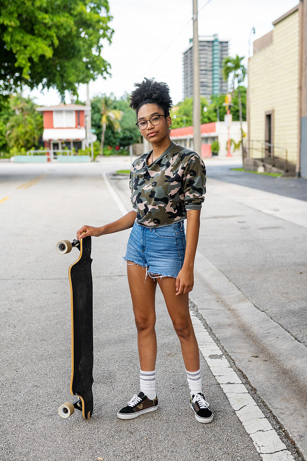 Portrait of an African American Teenage Girl with her Skateboard Outdoors on a Residential Street in Miami Photograph by Boogich