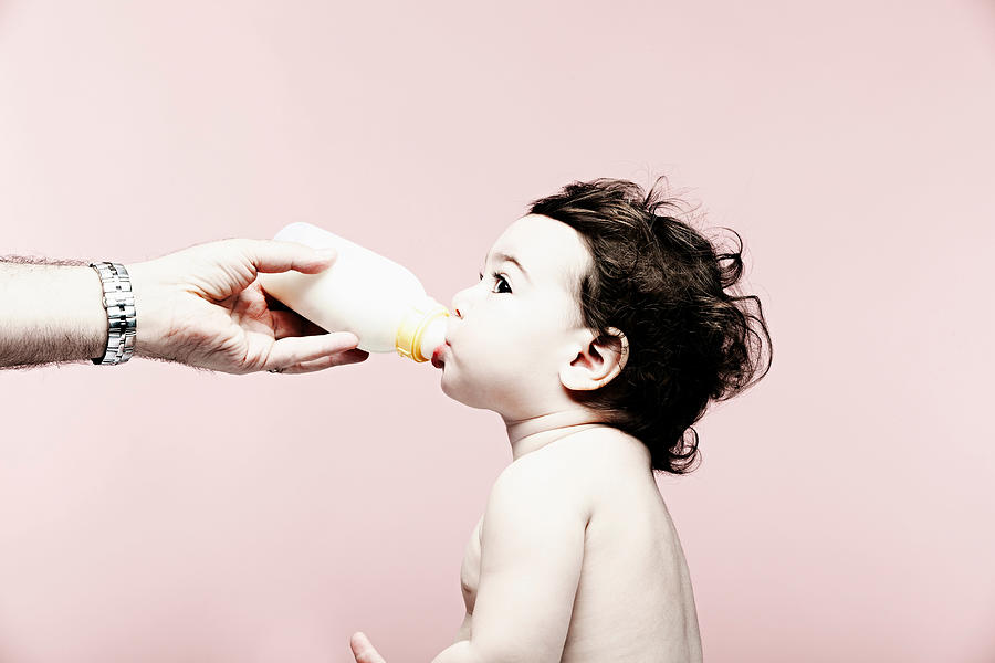 Portrait of baby girl drinking milk from bottle Photograph by Jpm