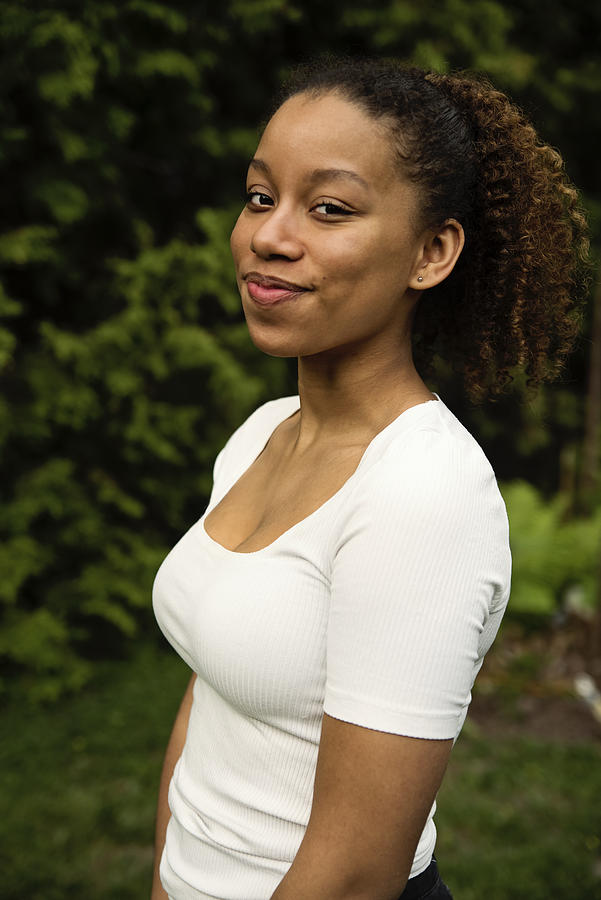Portrait of beautiful mixed-race teenage girl in backyard. Photograph by Martinedoucet