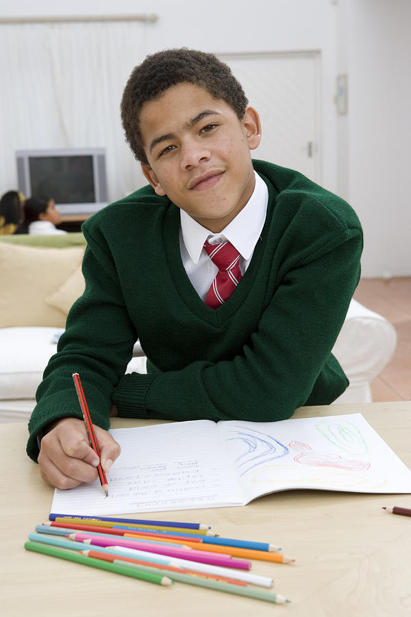Portrait of boy doing homework Photograph by Alistair Berg