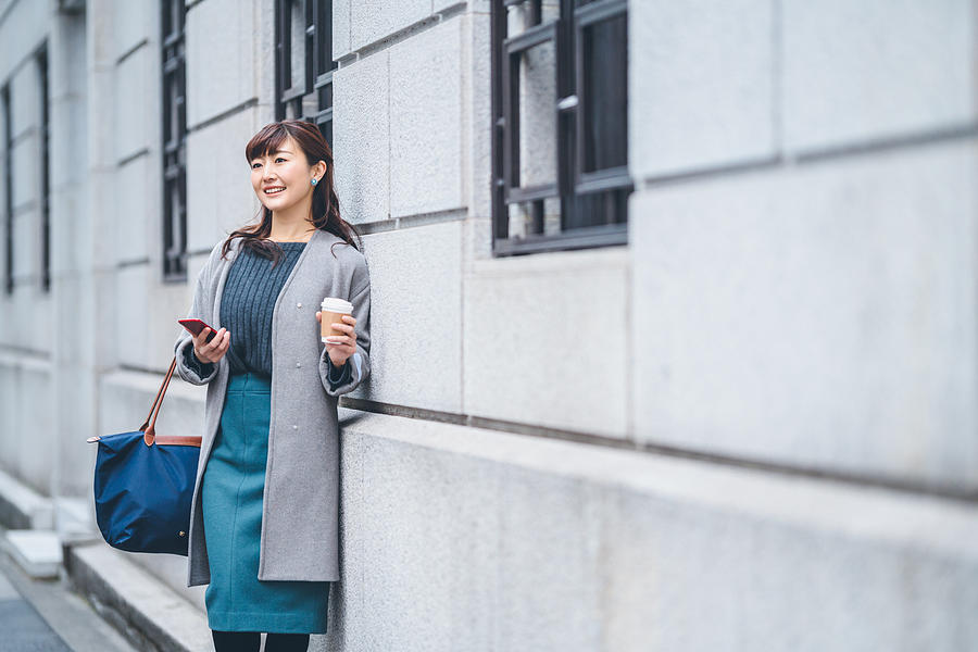 Portrait of businesswoman in street while holding coffee Photograph by Recep-bg