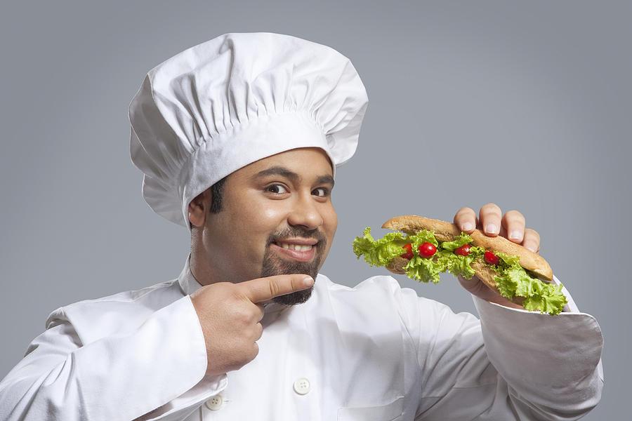 Portrait of chef pointing at sandwich Photograph by Ravi Ranjan