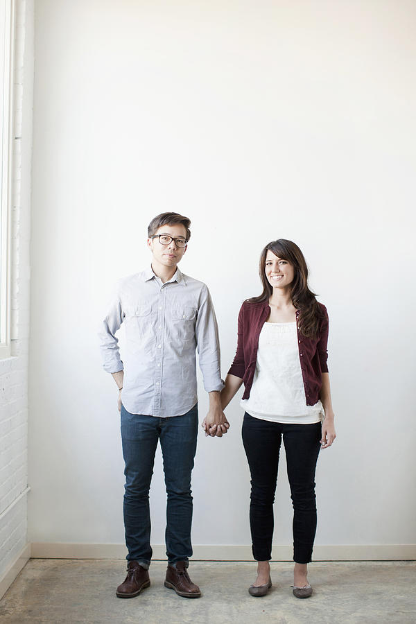 Portrait of couple holding hands indoors Photograph by Jessica Peterson