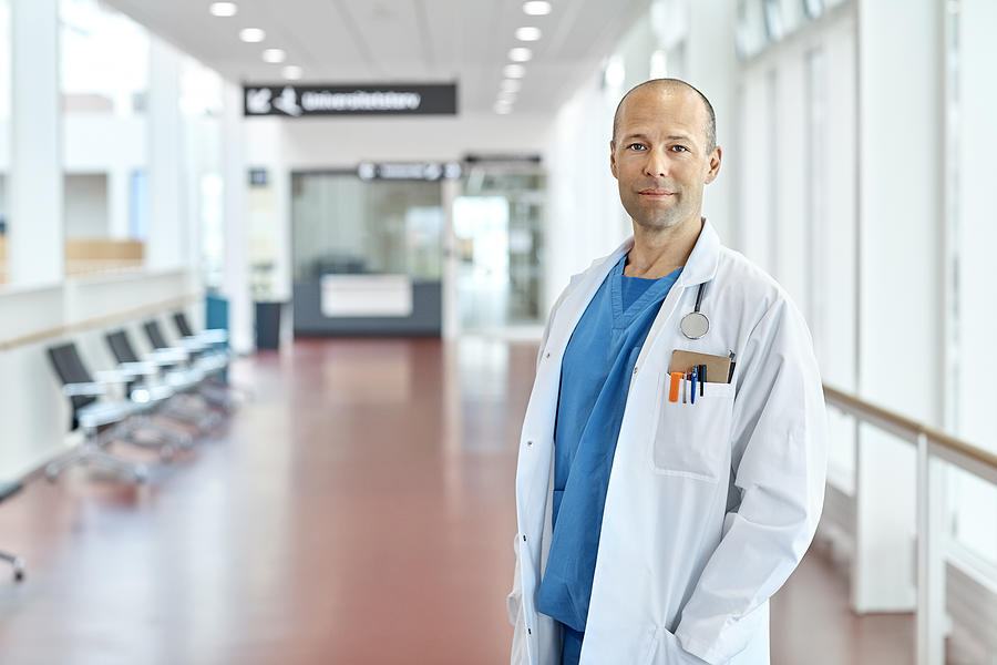 Portrait Of Doctor Standing In Hospital Corridor Photograph by Morsa Images