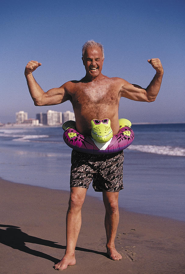 Portrait of elderly man flexing on beach Photograph by Cohen/Ostrow