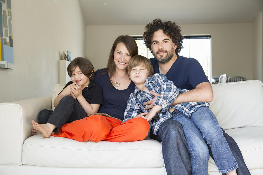 Portrait of family with two boys on sofa Photograph by David Jakle