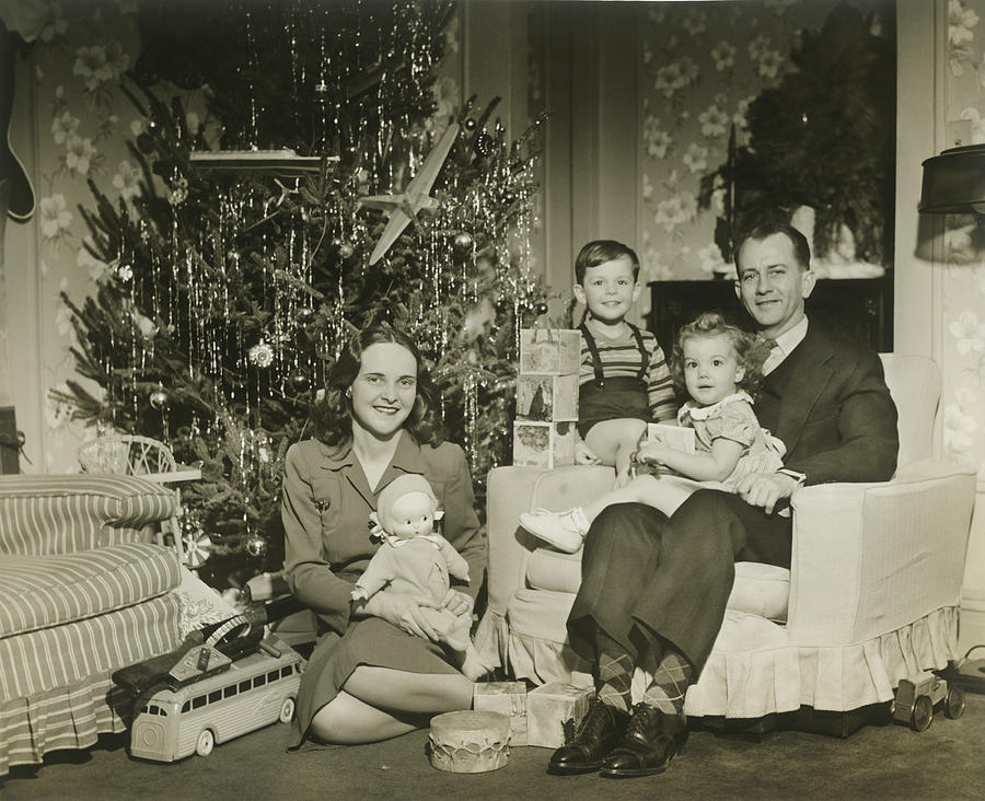 Portrait of family with two children (2-3 years) by Christmas tree in room Photograph by George Marks