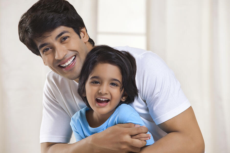 Portrait of father and son smiling Photograph by IndiaPix/IndiaPicture