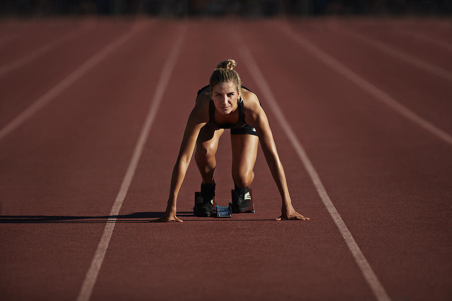 Portrait of female runner in start block Photograph by Klaus Vedfelt