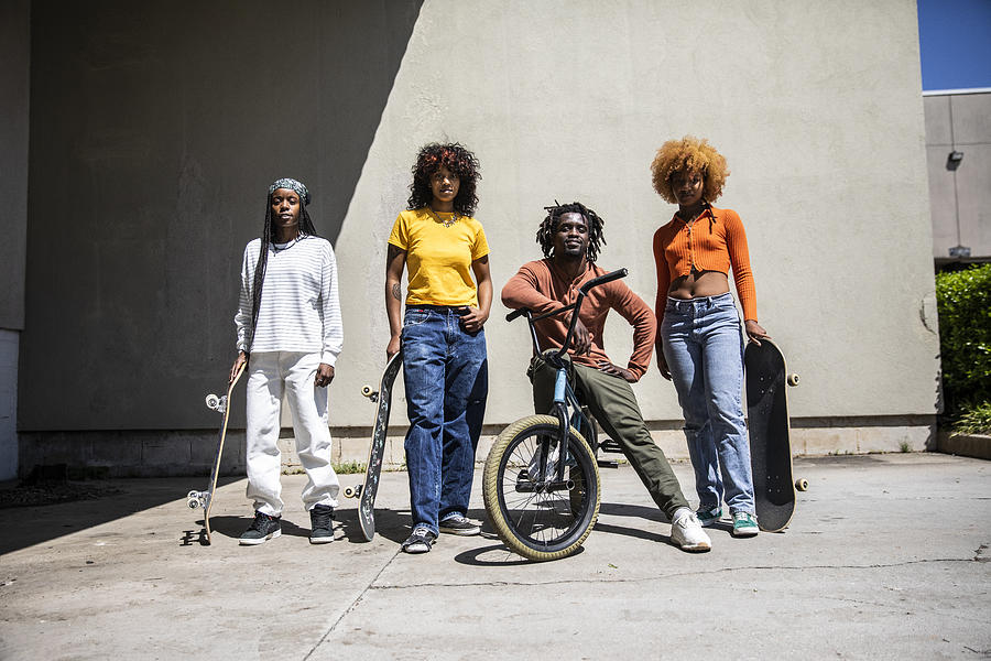 Portrait of female skateboarders and BMX rider in outdoor industrial environment Photograph by MoMo Productions