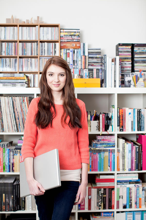 Portrait of female student in front of bookcase Photograph by Alys Tomlinson