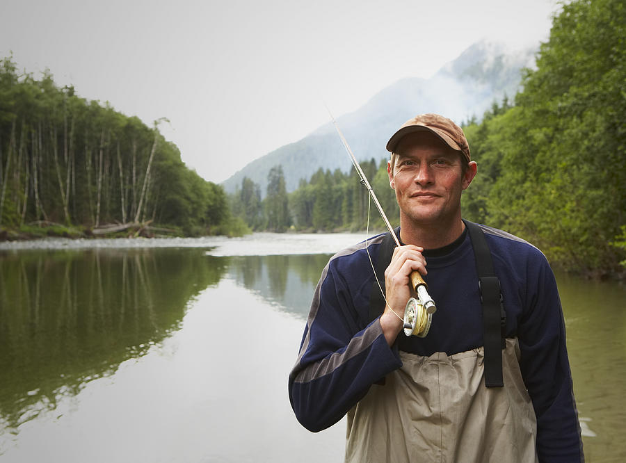 Portrait of fly fisherman standing in river Photograph by Thomas Northcut