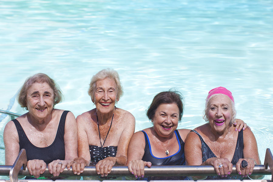 Portrait of four senior women in swimming pool Photograph by Zero Creatives