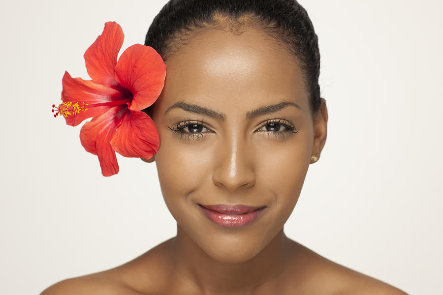 Portrait of fresh clear woman face with hibiscus flower. Photograph by RuslanDashinsky