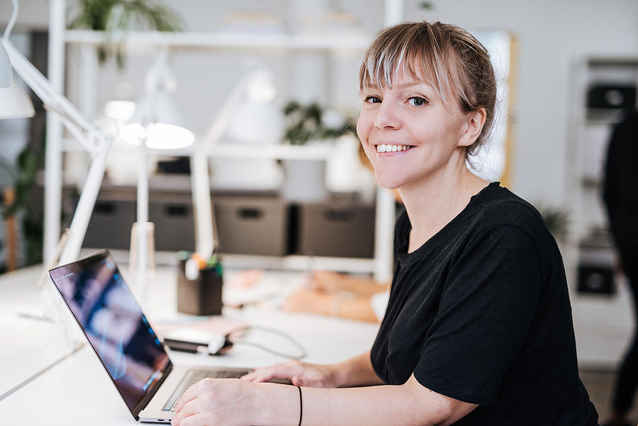 Portrait of graphic designer in Scandinavia, working on laptop. Photograph by Drazen_