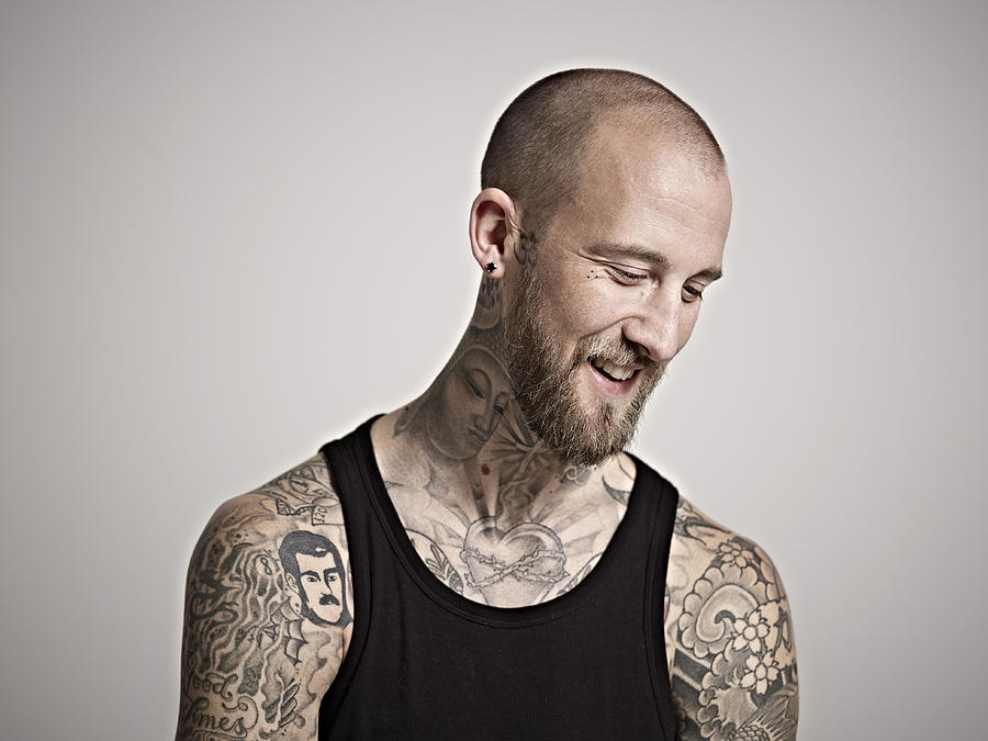 Portrait of heavily tattooed bearded male smiling. Photograph by Mike Harrington