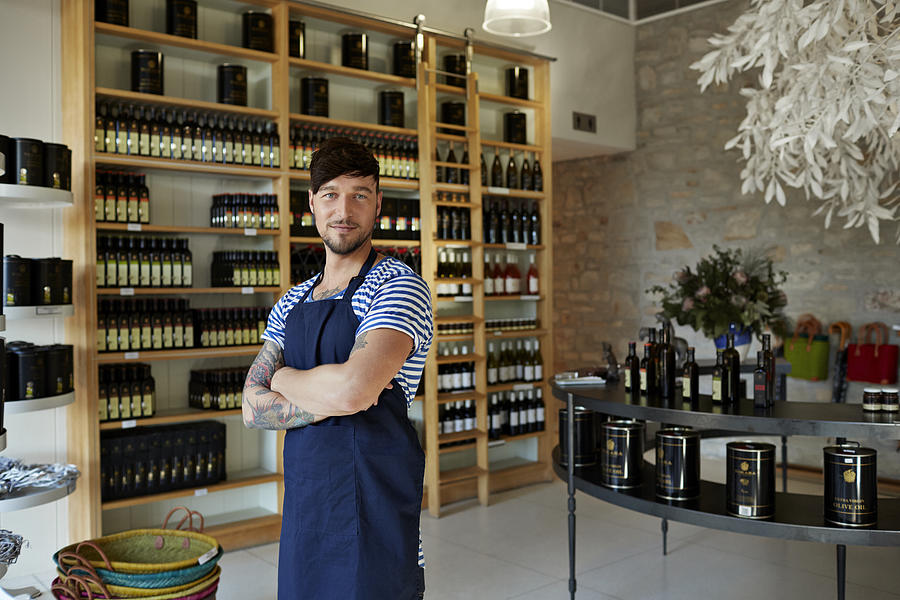 Portrait of hipster clerk in olive oil shop Photograph by Klaus Vedfelt