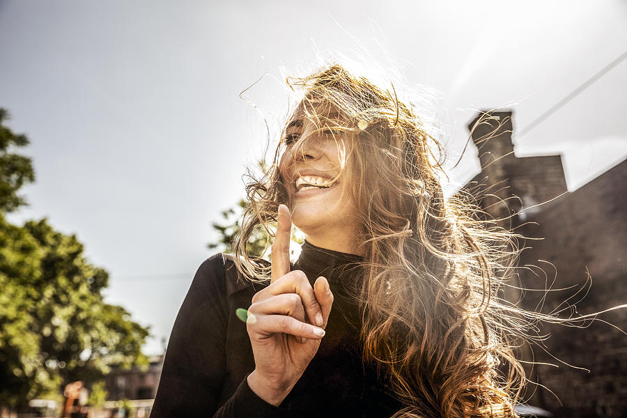 Portrait of laughing woman with blowing hair Photograph by Westend61
