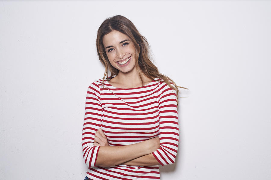 Portrait of laughing young woman wearing red-white striped shirt against white background Photograph by Westend61