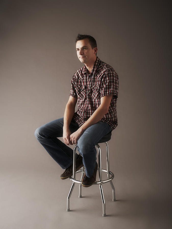Portrait of man sitting on stool Photograph by Thomas Northcut