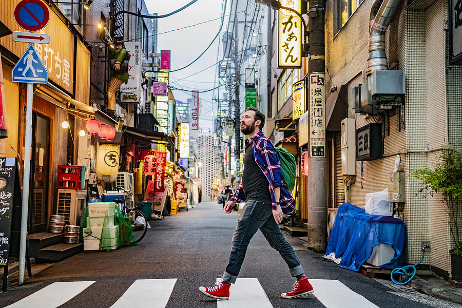Portrait of man walking on zebra crossing on Tokyo street Photograph by JohnnyGreig