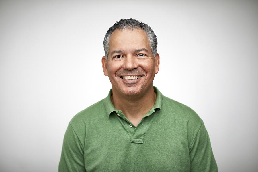 Portrait of mature man smiling against white Photograph by Morsa Images