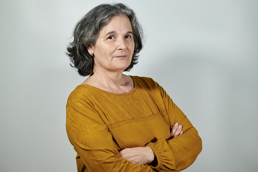 Portrait of mature woman with crossed arms on white background Photograph by F.J. Jimenez