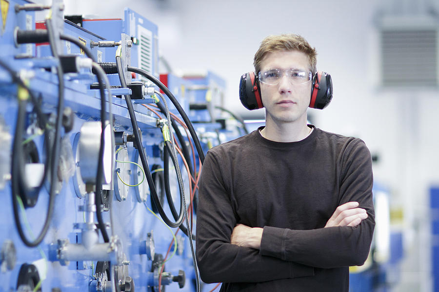 Portrait of mid adult male wearing ear protectors in engineering plant Photograph by Sigrid Gombert