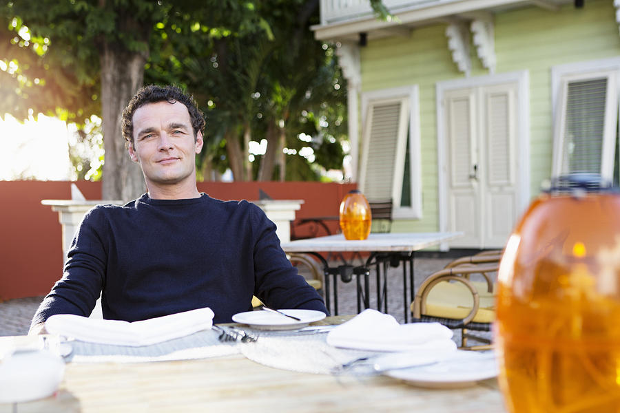 Portrait of mid adult man sitting in outdoor restaurant Photograph by Felix Wirth