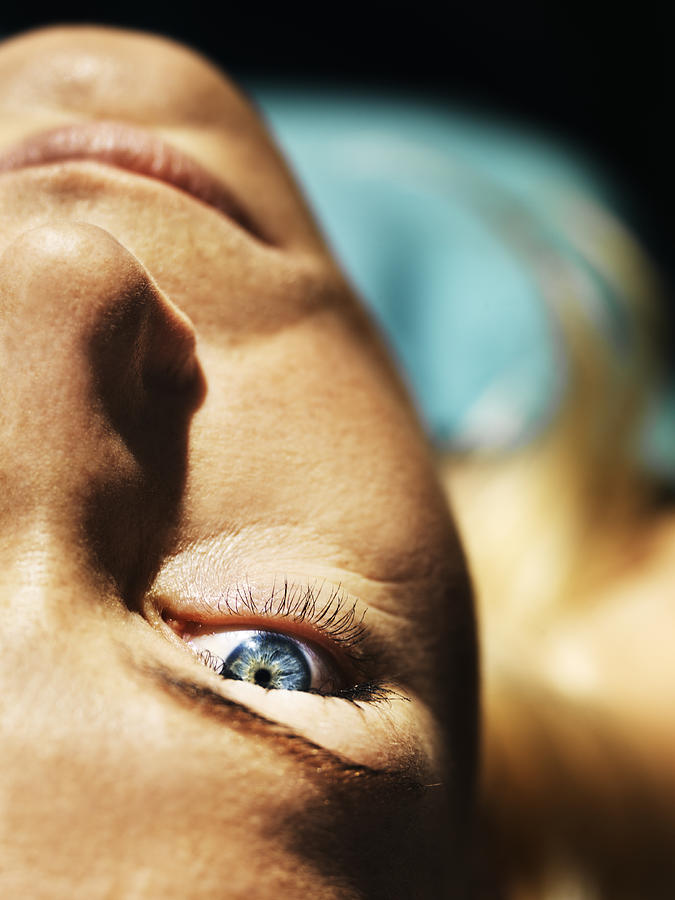 Portrait of mid adult woman lying, differential  focus Photograph by Henrik Sorensen