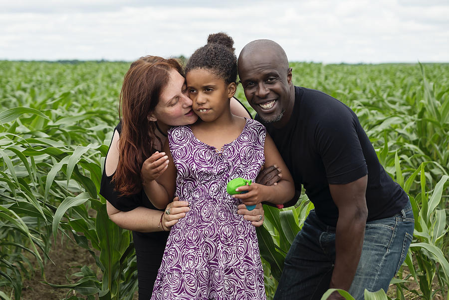 Portrait of mixed-race family with autist daughter in nature. Photograph by Martinedoucet