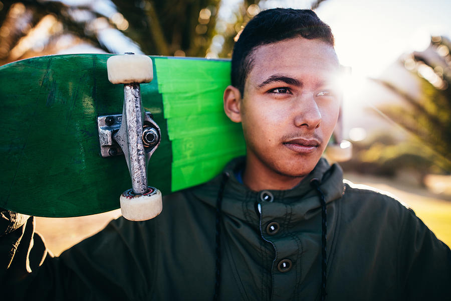 Portrait of Mixed Race Person Holding Skateboard Behind Head Photograph by Wundervisuals
