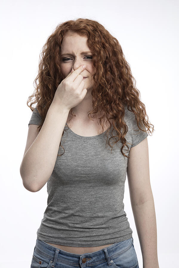 Portrait of redheaded teenage girl holding nose Photograph by Westend61