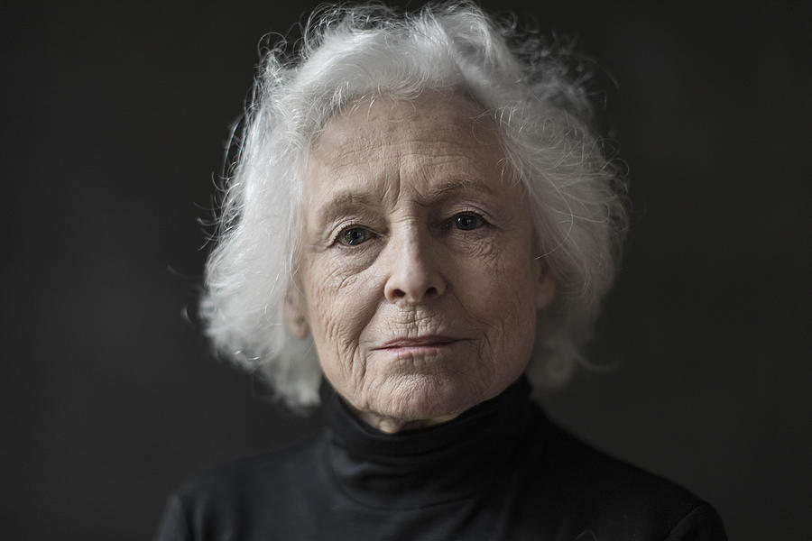 Portrait of serious senior woman against black background Photograph by The Good Brigade