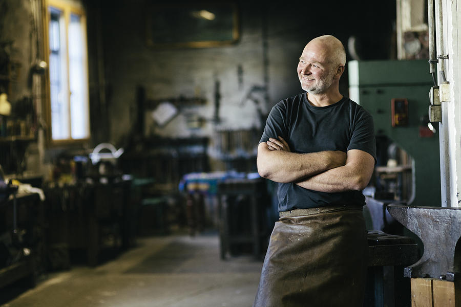Portrait of smiling blacksmith Photograph by Hinterhaus Productions
