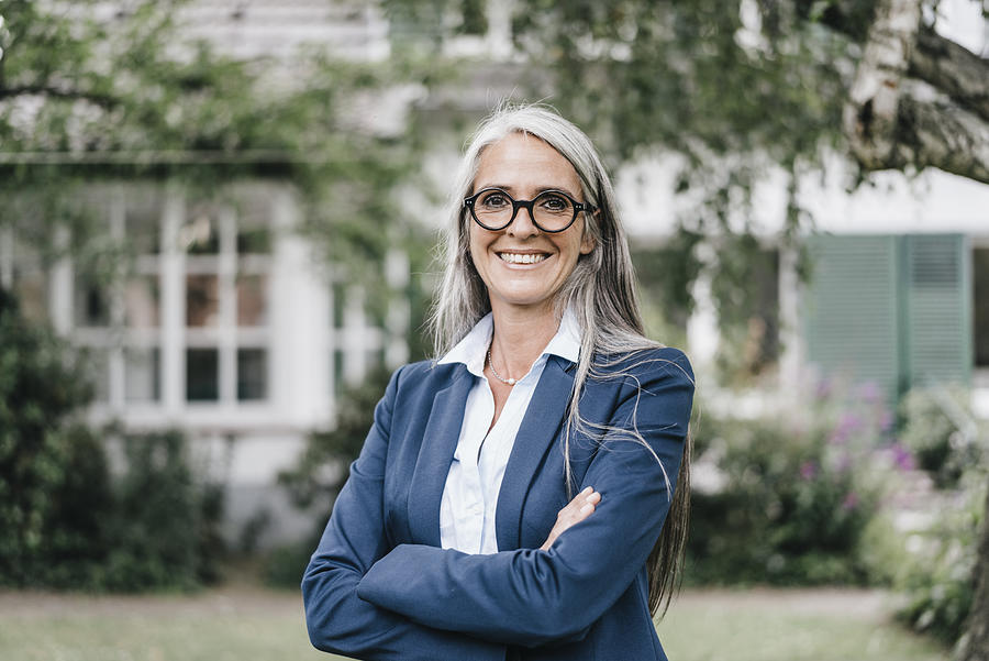 Portrait of smiling businesswoman wearing spectacles standing in the garden Photograph by Westend61