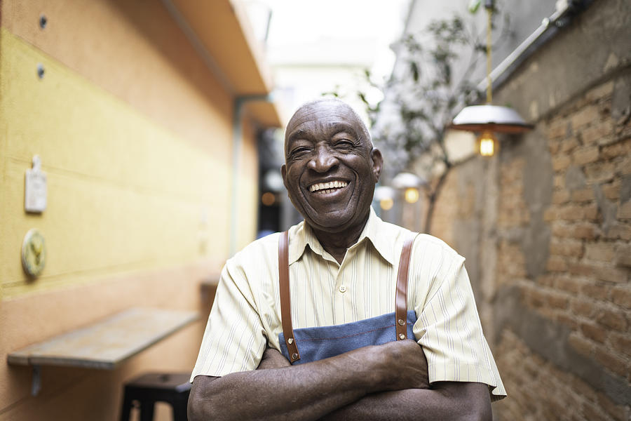 Portrait of smiling elderly waiter looking at camera Photograph by FG Trade