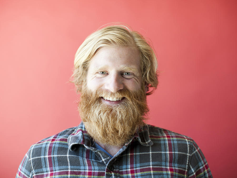 Portrait of smiling man with beard, studio shot Photograph by Jessica Peterson