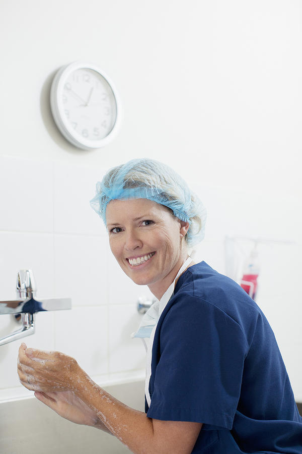 Portrait of smiling nurse washing hands Photograph by Sam Edwards