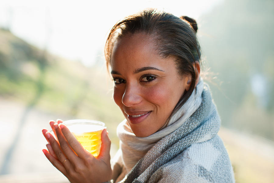Portrait of smiling woman in scarf drinking cider Photograph by Tom Merton