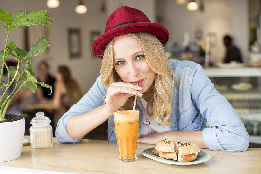 Portrait of smiling woman with smoothies Photograph by Oana Szekely