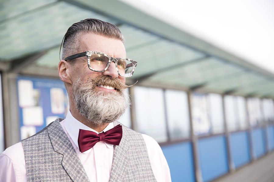 Portrait of stylish senior man with eyeglasses and handlebar moustache on pier Photograph by Jag Images