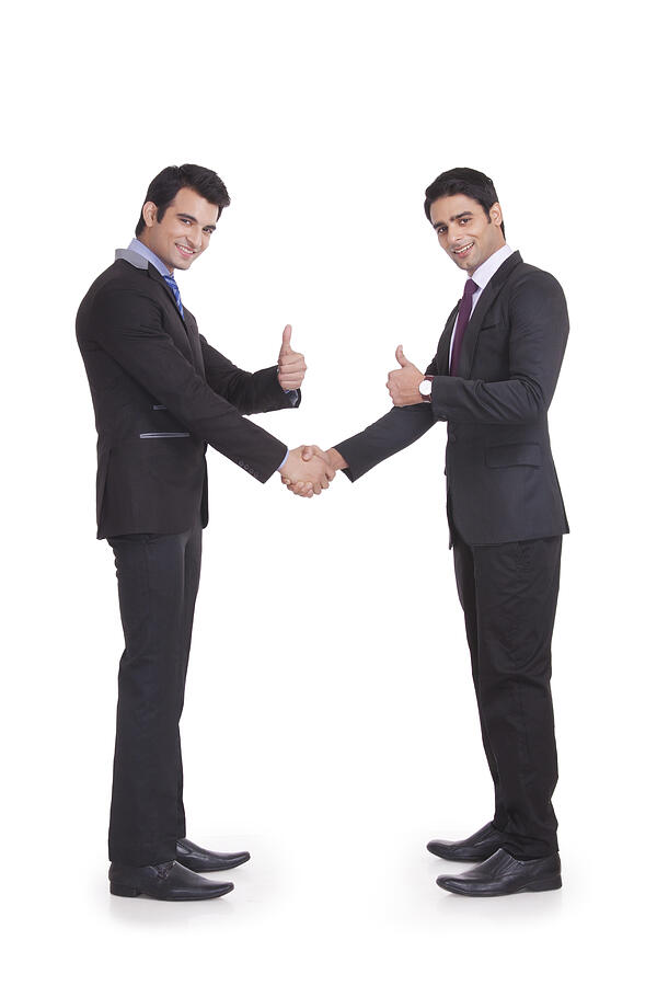Portrait of two businessmen giving thumbs up Photograph by IndiaPix/IndiaPicture